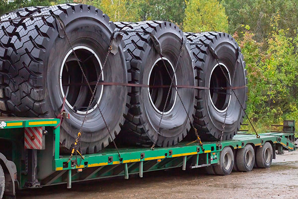 Huge wheels on a trailer for transportation, large road vehicles, bulky transport.